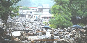 Locals walk across a makeshift bamboo and wooden crossing